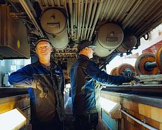 Zwei Mitarbeiter der RDC Deutschland Gruppe stehen in der Werkstattgrube unter einem Reisezugwagen.