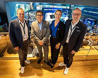 Florian Schuhbäck (Siemens Mobility), Markus Hunkel (CEO RDC Deutschland), Ida Posner (COO RDC) und Steffen Bobsien (Siemens Mobility) stehen auf der InnoTrans für ein Gruppenfoto beisammen.