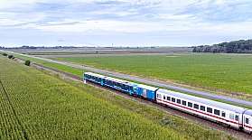 Auf der Bahnstrecke Niebüll nach Dagebüll ist ein NEG-Zug mit Kurswagen unterwegs.